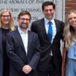 Four people smiling together outside a courthouse.